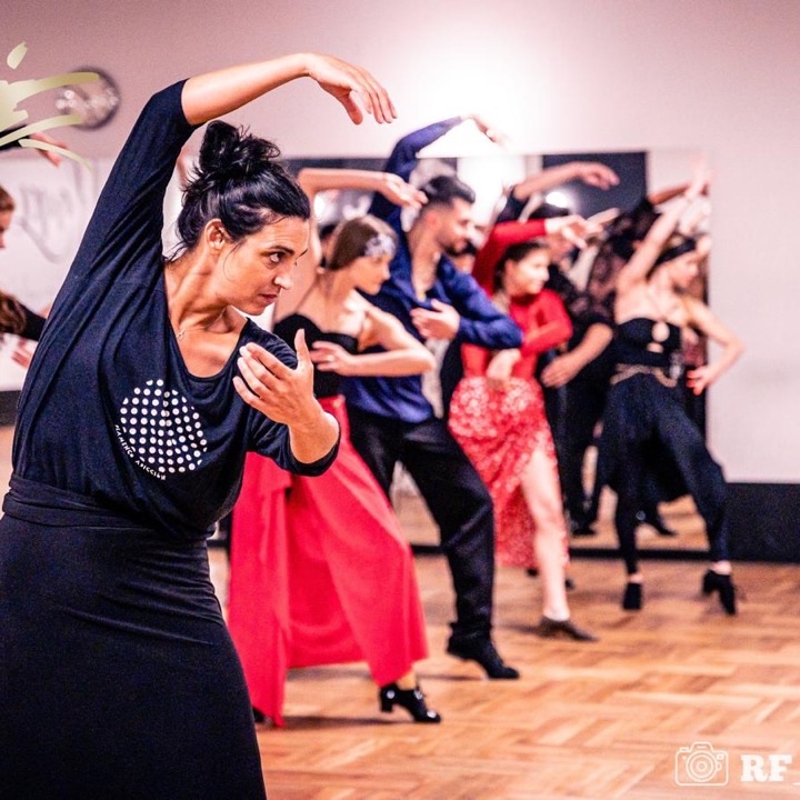 Instruktorka prowadząca zajęcia Latino Solo, za nią grupa w ruchu